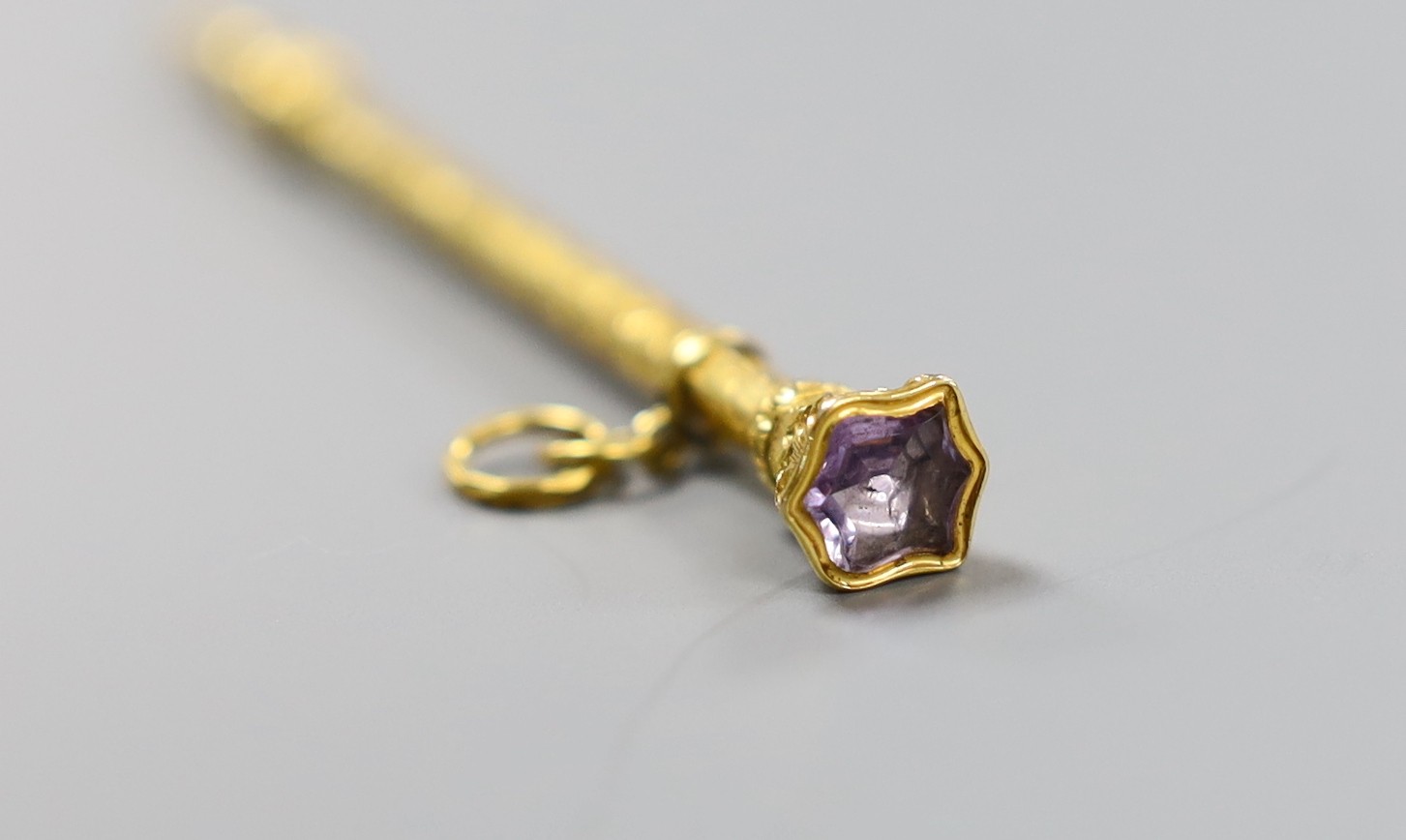 A Victorian chased yellow metal overlaid propelling pencil, with amethyst set terminal, 80mm.